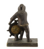 Lote 29 - "HOMEM DO LEME", RELÓGIO DE MESA - Escultura em bronze representando Homem com roda de leme. Relógio inserido na roda de leme com movimento de corda manual e mostrador com numeração romana e ponteiro de despertador. Dim: 23x17x10 cm. Nota: a fun - 4