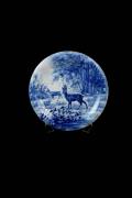 Lote 45 - Prato decorativo, em tons de azul com dois cervos, marcado na base com " E.I.C de Teixeira Lopes, M Vasco, 1950 5º ano. Nota: Sinais de uso e desgaste.