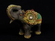 Lote 261 - Elefante em resina decorado com vidro, missangas, pedras e relevo, com 9 cm de altura. Nota: Sinais de uso.