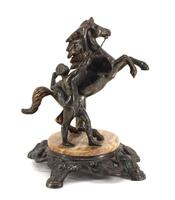 Lote 42 - FIGURA COM CAVALO, ESCULTURA - Em metal prateado representando figura masculina com cavalo assente em base de mármore castanho e metal prateado. Dim: 21 cm