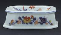 Lote 189 - VISTA ALEGRE, SALEIRO EM PORCELANA - Decoração policromada e dourada com flores. Dim: 3,5x11x8,5 cm. Nota: marca Nº 36 (1980-1992) e marca da Manufactura