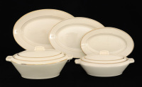 Lote 210 - LUSITANIA - CONJUNTO DE LOIÇA. Conjunto de Travessas, Terrinas e azeitoneira em porcelana da fabrica Lusitania em Coimbra. Serviço com decoração simples em porcelana creme com duplo filete a ouro. Todas as peças marcadas na base com o carimbo d