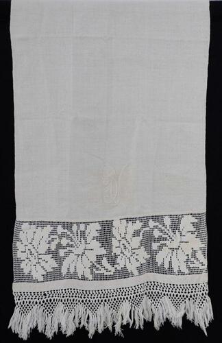 Lote 60 - TOALHA DE LINHO COM BORDADO FILÉ - Toalha em tecido branco de linho com monograma bordado, barras com bordado filé e remate em renda de crochet com franjas. Dim: 60x160 cm