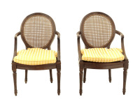 Lote 64 - FAUTEUILS ESTILO LUÍS XVI - Par de fauteuils em nogueira. Costas e assentos em palhinha com coxins em tecido de riscas. Braços entalhados e pés canelados. Dim: 86x53x47 cm