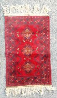 Lote 10 - TAPETE BOKHARA DE LÃ COM 114 X 69 CM - Tapete de lã da região de Bokhara, Turquemenistão. Dimensões: 114 x 69 cm. Nota: sinais de uso