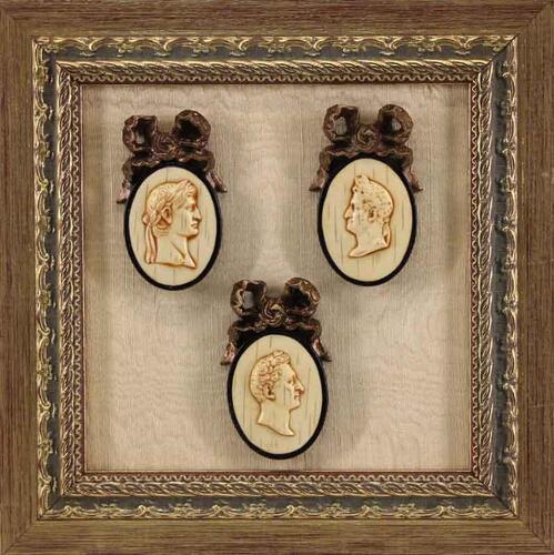 Lote 29 - CAMAFEUS DECORATIVOS - Conjunto de 3 camafeus em marfinite representando Bustos Romanos encimados por laços dourados aplicados em fundo de tecido com moldura em madeira dourada. Dim: 27x27 cm (moldura)