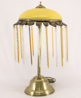 Lote 114 - CANDEEIRO DE MESA - em metal dourado com quebra luz em vidro amarelo e pingentes em vidro espiralado. Dim: 50 cm