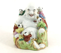 Lote 112 - BUDA EM PORCELANA - Figura de Buda com crianças em porcelana de Macau com decoração policromada e dourada. Dim: 21x16x10 cm. Nota: marcado na base