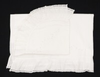 Lote 39 - LENÇOL E ALMOFADA DE CAMA DE BEBÉ COM BORDADOS - Conjunto de lençol e fronha de almofada em tecido branco bordado à mão com desenho de flores, remate com folhos. Dim: 102x76 cm e 25x45 cm