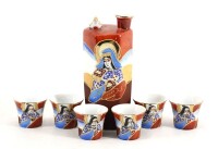 Lote 45 - CONJUNTO PARA SAKE EM PORCELANA DO JAPÃO - Composto de garrafa e 6 copos. Decoração policromada e dourada "Satsuma". Dim: 15 cm (garrafa) e 4 cm (copos)