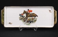 Lote 39 - TRAVESSA TORTEIRA - Em faiança com decoração policromada de motivos equestres. Pegas e filete dourados. Dim: 16x41 cm. Nota: falha no bordo