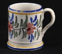 Lote 131 - VIÚVA LAMEGO, CANECA - Em faiança com decoração floral policromada. Dim: 9 cm. Nota: pequenas falhas no bordo. Marcada na base