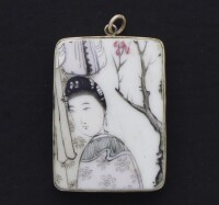 Lote 25 - PENDENTE ORIENTAL - Placa em porcelana com decoração policromada com "figura feminina", com aro e argola em metal prateado. Dim: 45x30 mm