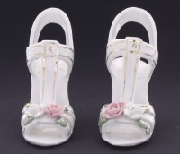 Lote 92 - SAPATOS EM PORCELANA - Par de sapatos de salto alto com decoração relevada e policromada de flores e dourados. Dim: 10x12x5 cm