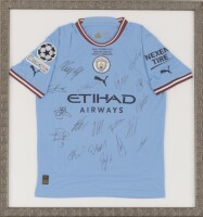 Lote 1 - MANCHESTER CITY - Camisola Oficial do Manchester City, AUTOGRAFADA pela equipa, Final Istanbul 2023, Puma. Dim: mancha 80x74 cm. Dim: moldura 87x82 cm. Nota: proveniente de colecção particular