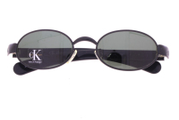 Lote 61 - CALVIN KLEIN, ÓCULOS DE SOL - Made in Italy, modelo em metal lacado a negro com lentes cinzentas, hastes em massa preta com marca gravada, Refª CK 1002 1 52-20 135. Dim: 14 cm. Nota: sem uso