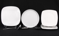 Lote 187 - CONJUNTO DIVERSO - Composto de 4 pratos de servir em porcelana monocroma branca, concha de sopa em inox e colher para massas. Dim: 33x33 cm (prato maior). Nota: um prato com falha no bordo