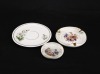 Lote 90 - ARTIBUS, CONJUNTO EM PORCELANA - Composto de 1 jarra, 1 garrafa, 1 chávena de chá com pires, 1 prato e 2 cinzeiros. Decorações policromadas diversas. Dim: 23 cm (garrafa) - 4