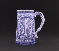 Lote 124 - CANECA EM FAIANÇA - Made in Japan, decoração relevada em tom azul com paisagem, marcada na base. Dim: 16 cm. Nota: sinais de uso