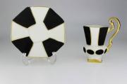 Lote 19 - Chávena miniatura com pires em porcelana T.Limoges, decoração geométrica em preto e bege com friso dourado, marcas na base, para coleccionadores