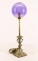 Lote 345 - CANDEEIRO DE MESA - Em metal dourado com globo em vidro roxo. Dim: 47 cm