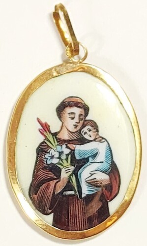 Lote 31 - MEDALHA EM OURO 750 - medalha com parte central em esmalte ostentando a imagem de santo António em policromia numa das faces e a inscrição "Sto Antonio", no verso, encastrada em aro com argola de suspensão em ouro contrastado de 750 milésimas. D