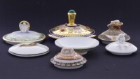 Lote 39 - TAMPAS, PORCELANA -Conjunto de 7 peças em porcelana, composto por 6 tampas e 1 covilhete, em porcelana, com decorções e tamanhos diferentes. Dim.: 14 cm (maior) e 8 cm menor). Nota: com sinais de armazenamento