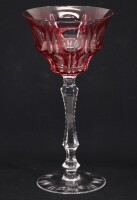 Lote 65 - COPO DE PÉ EM CRISTAL - Copo em cristal bordeaux e translucido com decoração lapidada. Pé e base translúcidos. Dim: 21 cm. Nota: ligeiras falhas no bordo