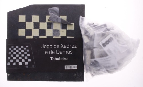 Lote 178 - JOGO DE XADREZ COM TABULEIRO EM PEDRA - Tabuleiro em pedra preta e bege com 16 + 15 peças de jogo de xadrez. Dim: 34x34 cm (tabuleiro). Nota: tabuleiro com canto partido e falta de um peão preto