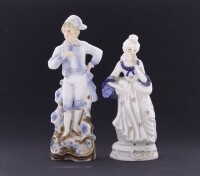 Lote 23 - FIGURAS DECORATIVAS EM PORCELANA - Par de figuras com decoração a azul e ornamentos dourados. Dim: 23 cm (maior). Nota: sinais de uso