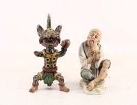 Lote 134 - FIGURAS DECORATIVAS - Conjunto de 2 peças, composto por figura oriental em biscuit policromado e instrumento musical de sopro em forma de tigre, em cerâmica policromada. Dim: 21 cm (maior). Nota: sinais de uso, peças com falhas e defeitos