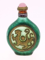 Lote 110 - SNUFF BOTTLE ORIENTAL - Em metal esmaltado de verde e dourado com decoração zoomórfica e tampa com cabuchão de pedra rosa. Dim: 7,5 cm. Nota: algumas falhas nos esmaltes