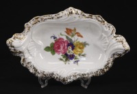 Lote 300 - V&A, COVILHETE EM PORCELANA - Decoração floral policromada, bordo recortado com dourados, marcado na base. Dim: 3x18x12 cm