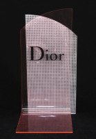 Lote 216 - DIOR, EXPOSITOR PUBLICITÁRIO - Em acrílico rosa e prateado com inscrição DIOR a negro. Dim: 39x20x20 cm