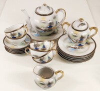 Lote 89 - SERVIÇO DE CHÁ EM PORCELANA JAPONESA - para seis pessoas, composto por bule com prato, leiteira e açucareiro, seis chávenas, cinco pires e seis pratos de sobremesa, todos decorados à mão em policromia com paisagem japonesa com pagodes e o Monte 