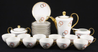 Lote 49 - VISTA ALEGRE, SERVIÇO DE CHÁ - Conjunto de 27 peças em porcelana marcada na base (1947-1968), decoração com círculos em vermelho e dourado, composto por bule, leiteira, açucareiro e 12 chávenas com pires. Dim: 20 cm (bule)