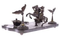 Lote 6 - TINTEIRO EM BRONZE E MÁRMORE ITALIANO (1940-50s)- Tinteiro da (1ª metade do Séc. XX) em bronze decorado com figuras de guerreiro a cavalo e águias. Base em mármore italiano moldada assente em 4 pés de bronze. Dim. 40x25x3.7cm. Tinteiro similar es