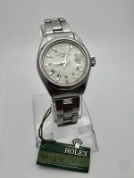 Lote 1 - ROLEX, RELÓGIO DE PULSO - Modelo Rolex Oyster Perpetual Date Lady, Ref. 6919, de 1977, caixa em aço com 26 mm e bracelete em aço. Movimento automático. Mostrador branco com marcadores, numeros romanos e data, vidro em plexiglas. Relógio idêntico 