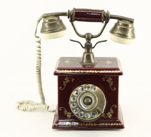 Lote 29 - TELEFONE ANTIGO - com corpo em porcelana bordeaux pintada com grinaldas de folhas douradas, telefone com disco em latão. Dimensão: 22,5x19,5x28 cm. Nota: bom estado geral, funcional