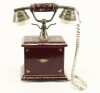 Lote 29 - TELEFONE ANTIGO - com corpo em porcelana bordeaux pintada com grinaldas de folhas douradas, telefone com disco em latão. Dimensão: 22,5x19,5x28 cm. Nota: bom estado geral, funcional - 4