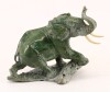 Lote 32 - ELEFANTE, ESCULTURA - Em mármore verde mesclado com presas em osso. Dim: 16x20x12 cm. Nota: assinada P.M. Zibote