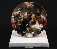 Lote 153 - VISTA ALEGRE, FESTA DE NATAL 2002 - Prato em porcelana marcada na base (a partir de 2001), edição de 2002, decoração exclusiva com detalhe do quadro "L`Adoration des Bergers”, série limitada não numerada de 60.000 exemplares. Dim: 19,5 cm (diâm