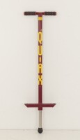 Lote 205 - QUIAX, POGO-STICK - Saltador em metal com decoração em vermelho e amarelo, peso máximo 30 Kg. Dim: 98 cm. Nota: sinais de uso