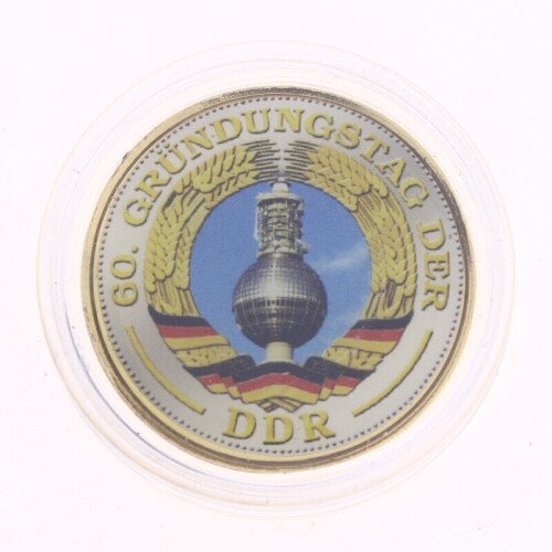 Lote 23 - ALEMANHA DEMOCRÁTICA, MEDALHA TOKEN - Medalha em liga de metal dourada de 5 Marcos comemorativa dos 60 Anos da República Democrática Alemã. Reverso impresso a cores. Dim: 30 mm (diâmetro). Nota: apresentada em alvéolo