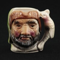 Lote 59 - TOBY JUG - Jarro em faiança em forma de figura com arara, decoração policromada. Dim: 8 cm. Nota: sinais de uso