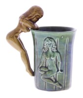 Lote 60 - CANECA EM FAIANÇA - Caneca com pega em forma de mulher e desenho de mulher na caneca, em tons de verde e pega castanha de cor preto, para vasos grandes, Inclui vaso.. Nota com sinais de armazenamento