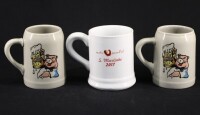 Lote 71 - CANECAS EM PORCELANA - Conjunto de 3 canecas sendo 1 branca com decoração policromada alusiva ao S. Martinho de Penafiel e 2 cinzentas com logotipo policromado de figura de porco com caneca. Dim: 11 cm