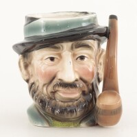 Lote 140 - TOBY MUG - Caneca em faiança em forma de homem e pega em forma de cachimbo, decoração policromada, marcada na base. Dim: 13 cm