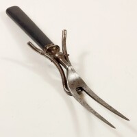 Lote 100 - GARFO DE CARNE COM SUPORTE - da primeira metade do século XX, com cabo em ébano e suporte retráctil, interessante peça de design industrial. Pequenos sinais de uso. Comprimento: 26,4 cm