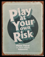 Lote 223 - PLAY AT YOUR OWN RISK - Impressão decorativa em chapa de metal, motivo "Play At Your Own Risk". Dim: mancha 39x30 cm